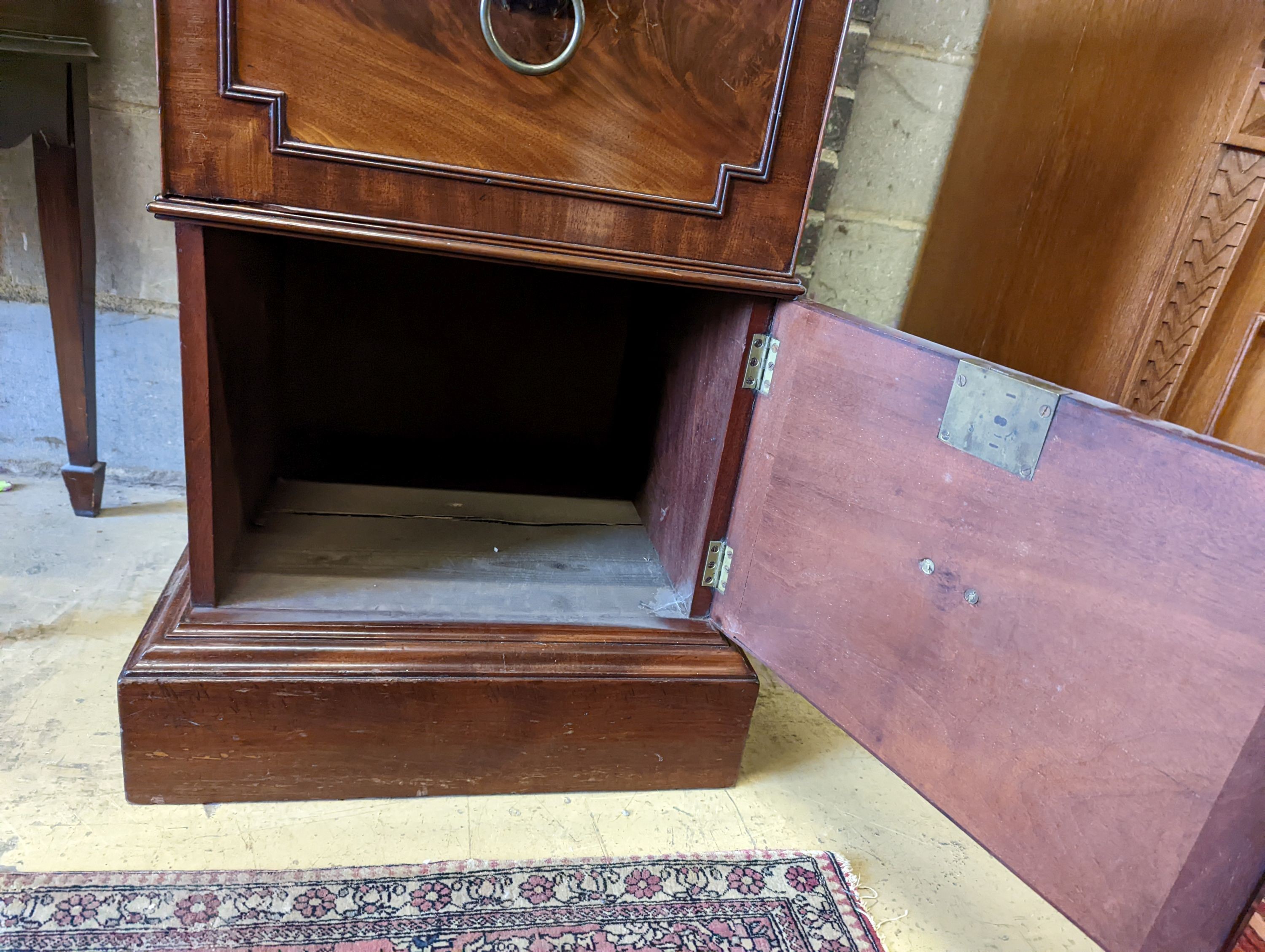 A George III mahogany pedestal designed by C. Wilson, with twin flap top, cellaret drawer now with two decanters and base cupboard, width 53cm, height 87cm